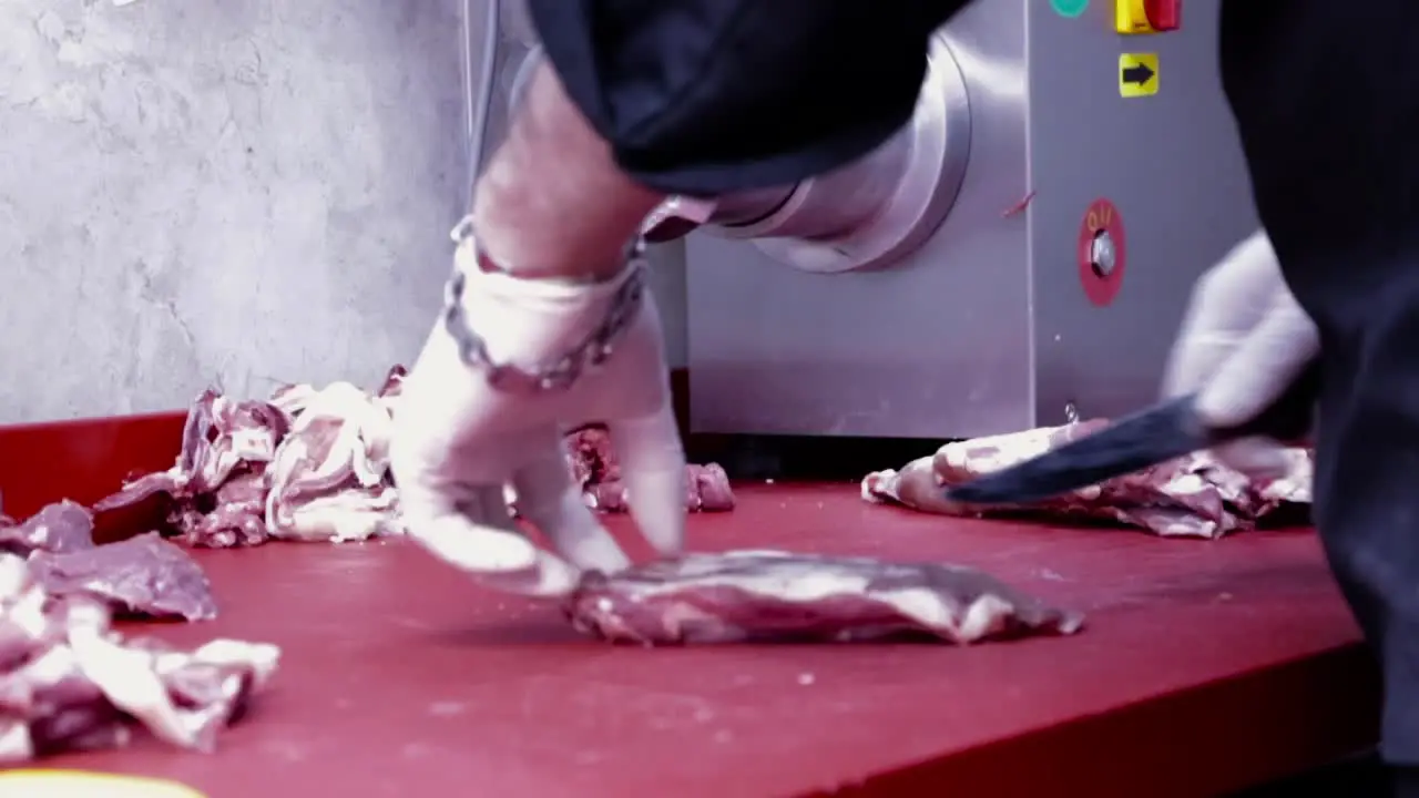 the male chef cuts meat on a cutting Board in the restaurant