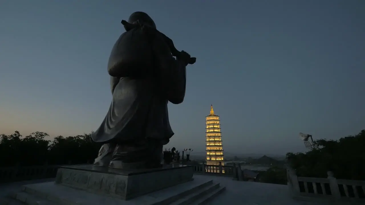 Buddha statue and tower pagoda in the dusk Bai Dinh Temple Vietnam