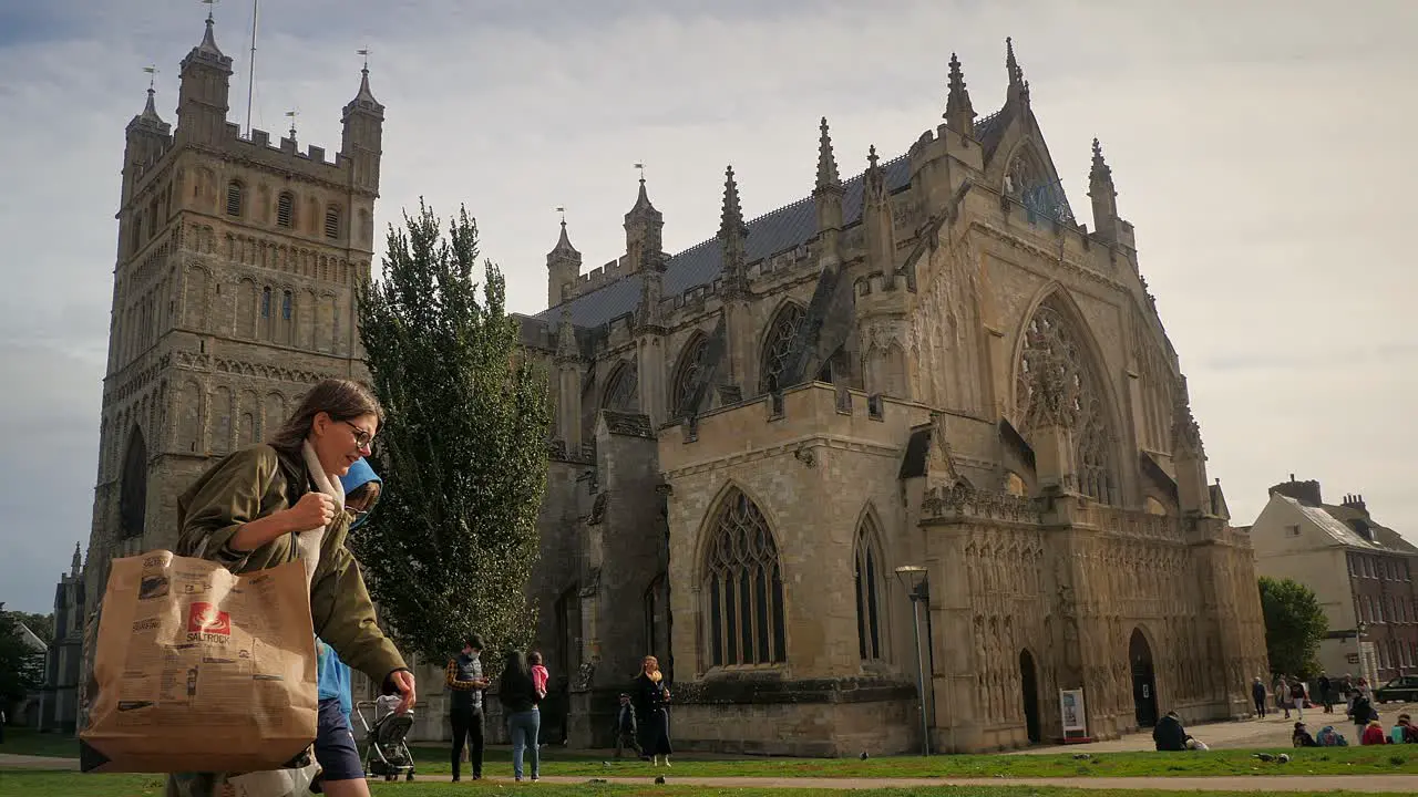 People mingle and wander around the historic and ornate Cathedral Church of Saint Peter in Exeter Devon UK on a busy Saturday afternoon in early autumn