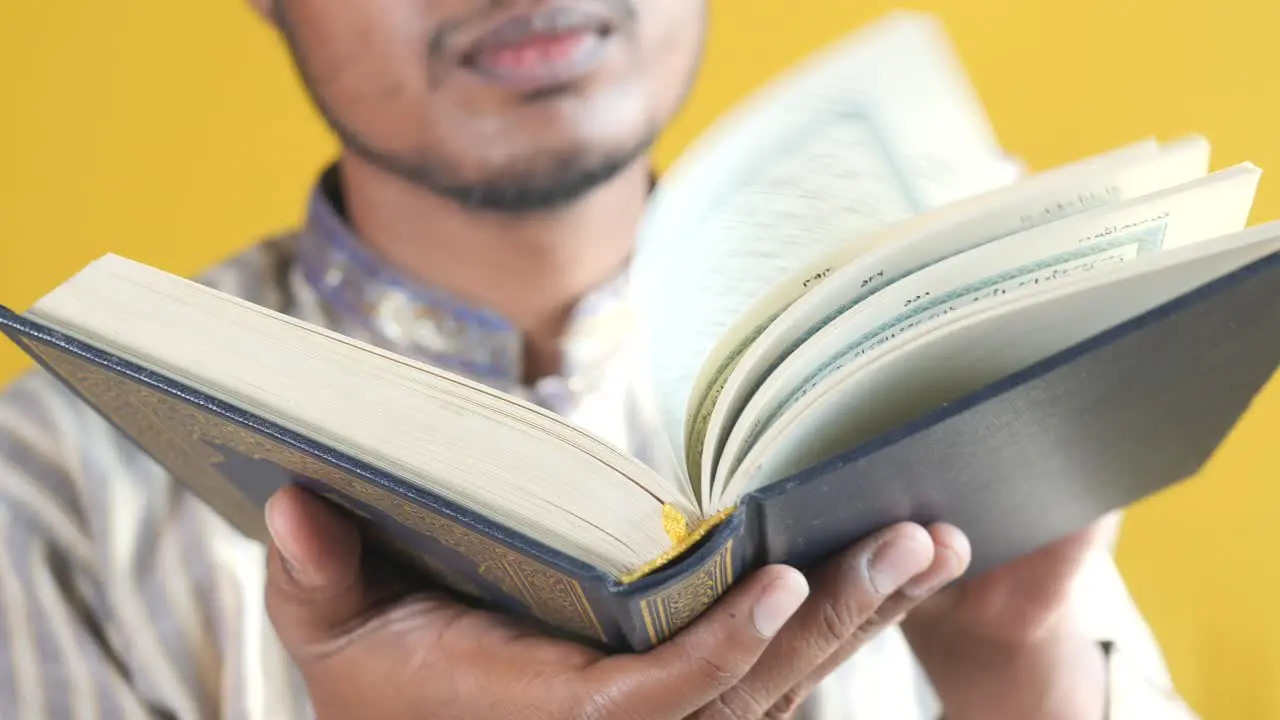 Muslim man hand holding holy book quran