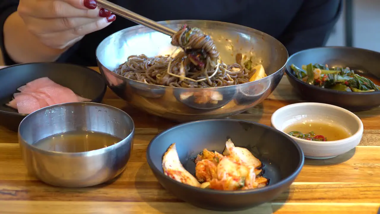 Eating Delicious Korean Buckwheat Noodles With A Pair Of Chopsticks close up