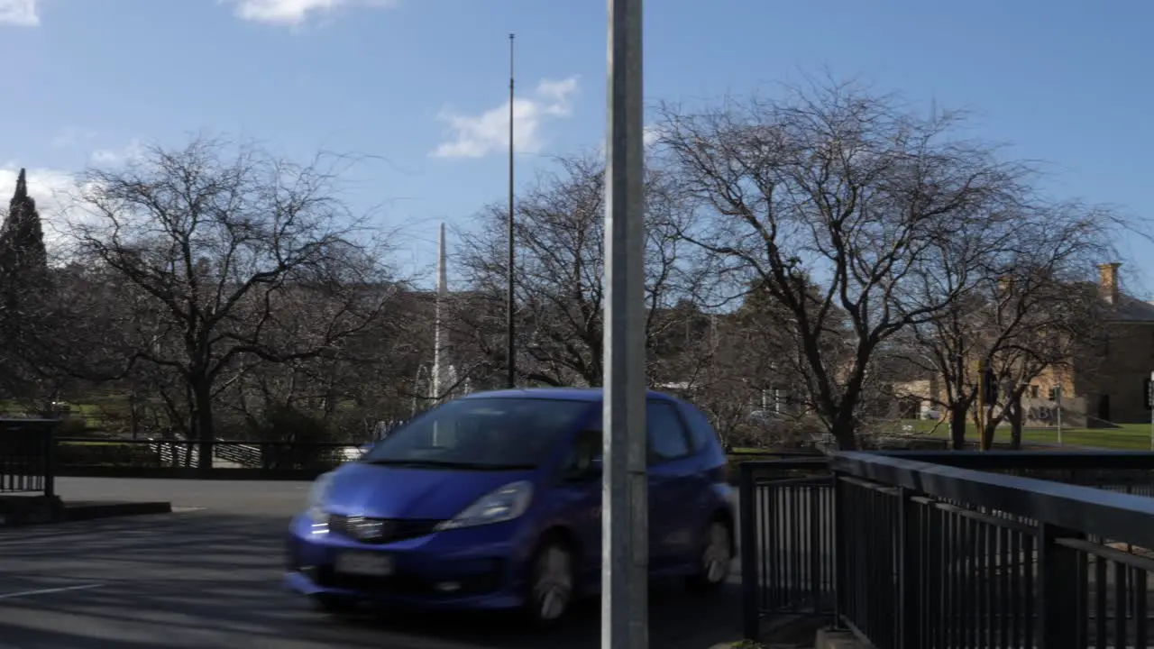 Vehicles drive past ABC roundabout in Hobart Tasmania on sunny winter day