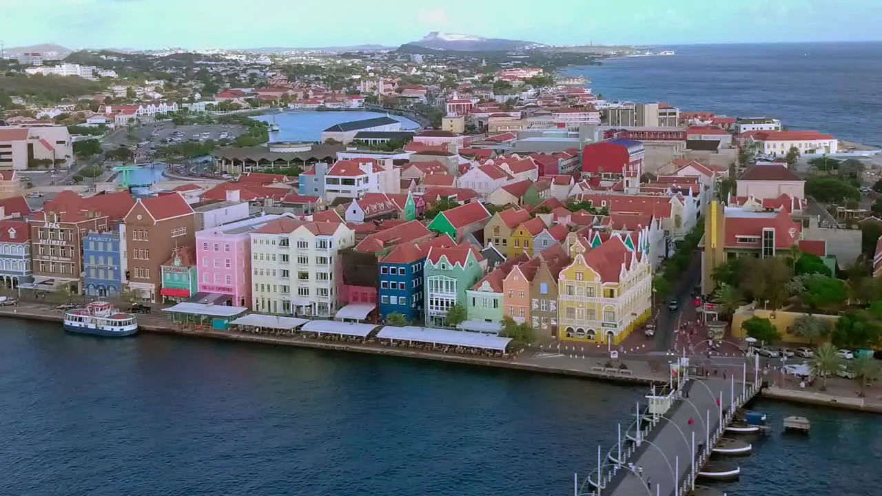 Colorful historic building of downtown Willemstad in Curacao panning aerial shot of waterfront