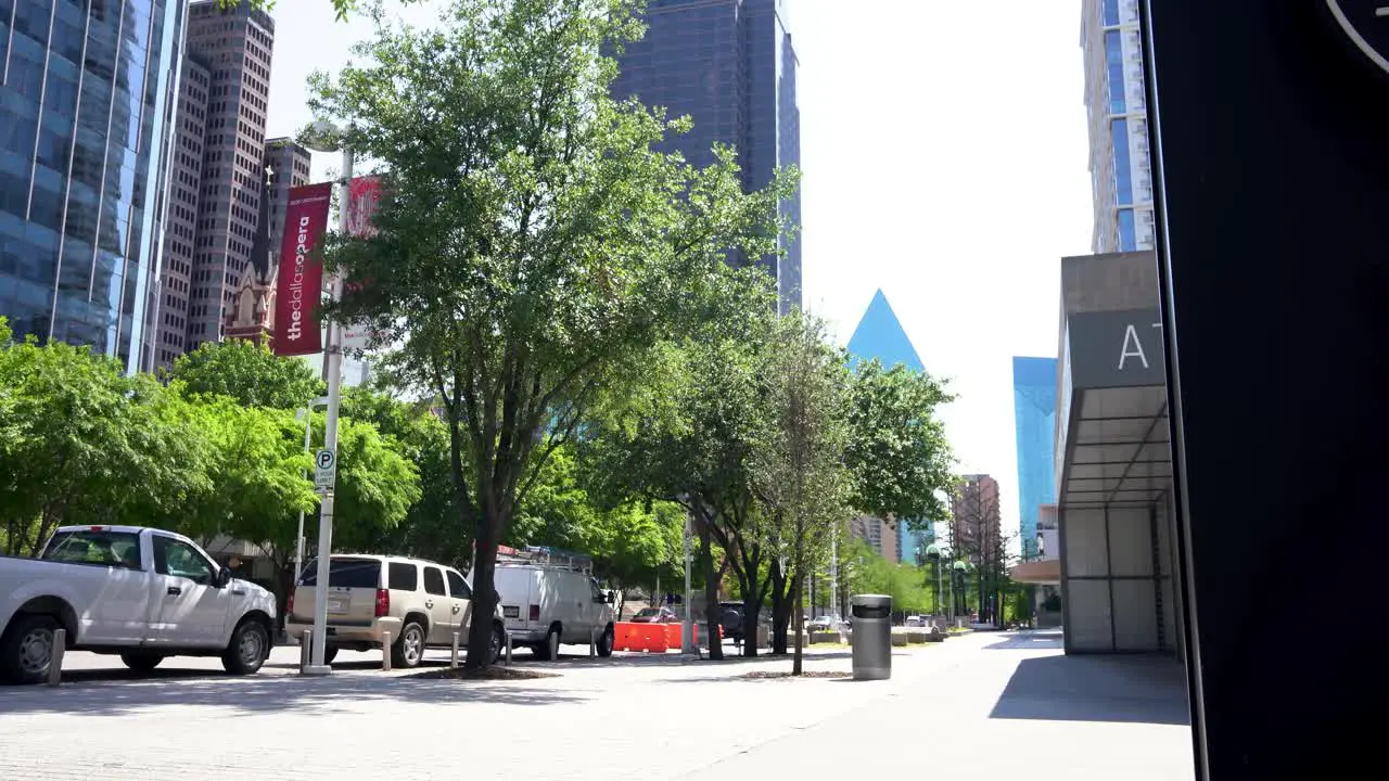 Clean Dallas street with office buildings parked cars and trees