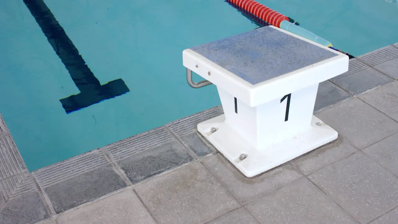 Starting block number one stands ready at a swimming pool's edge