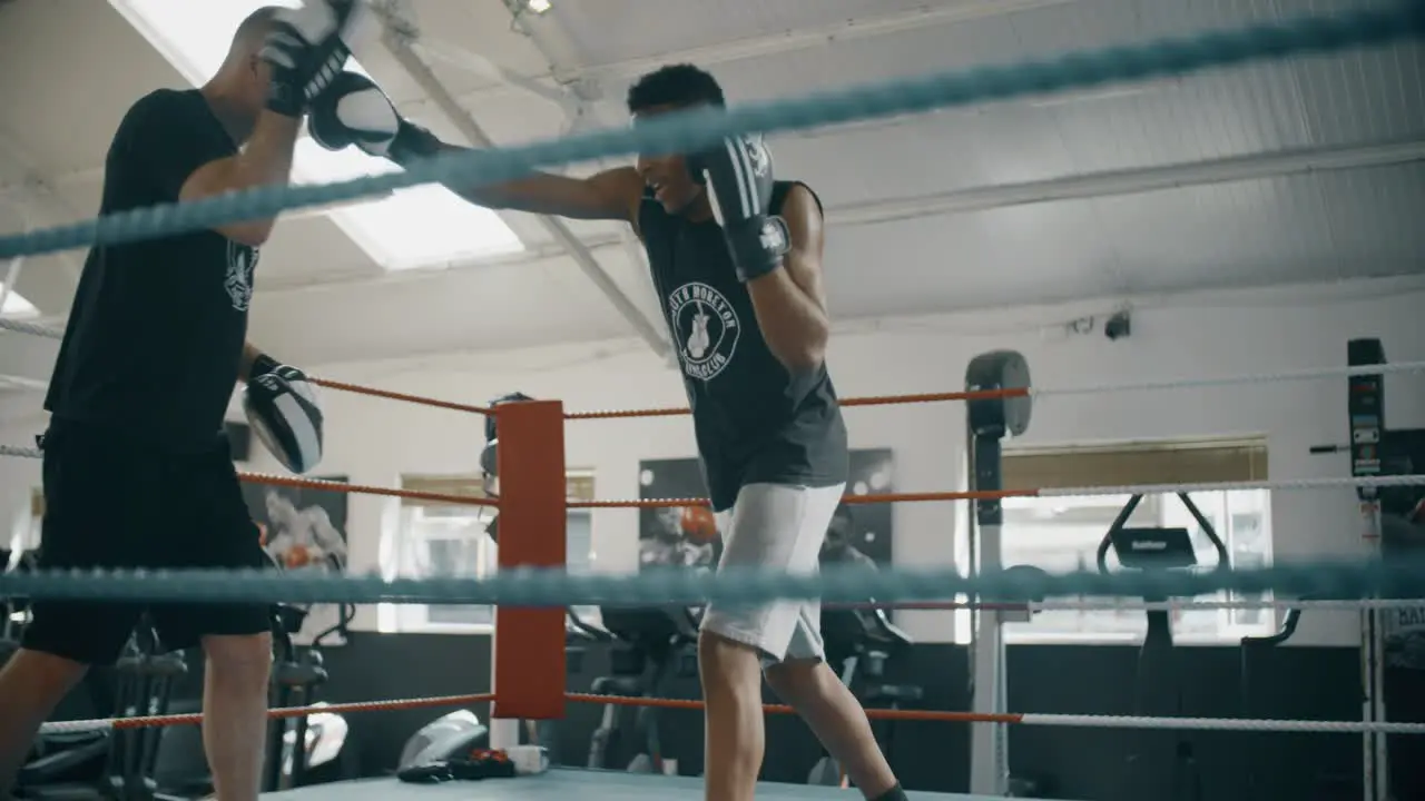 Young Boxer Training with Coach