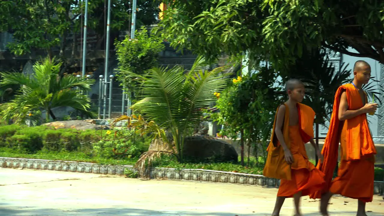 Pan Shot of Young Monks Walking Barefoot in Pagoda