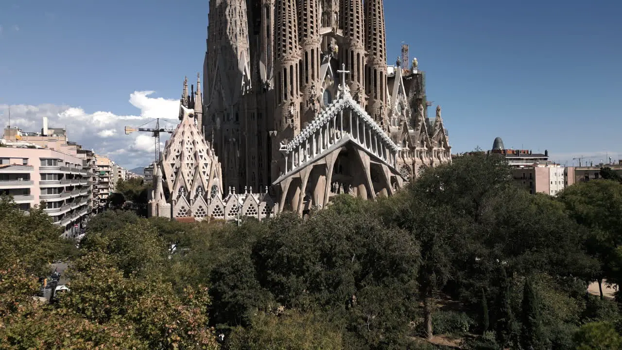 Drone Shot Through Trees Revealing the La Sagrada Familia in Barcelona Spain