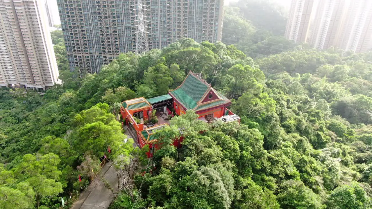 Classic Temple in Hong Kong surrounded by lush green mountain terrain Aerial view