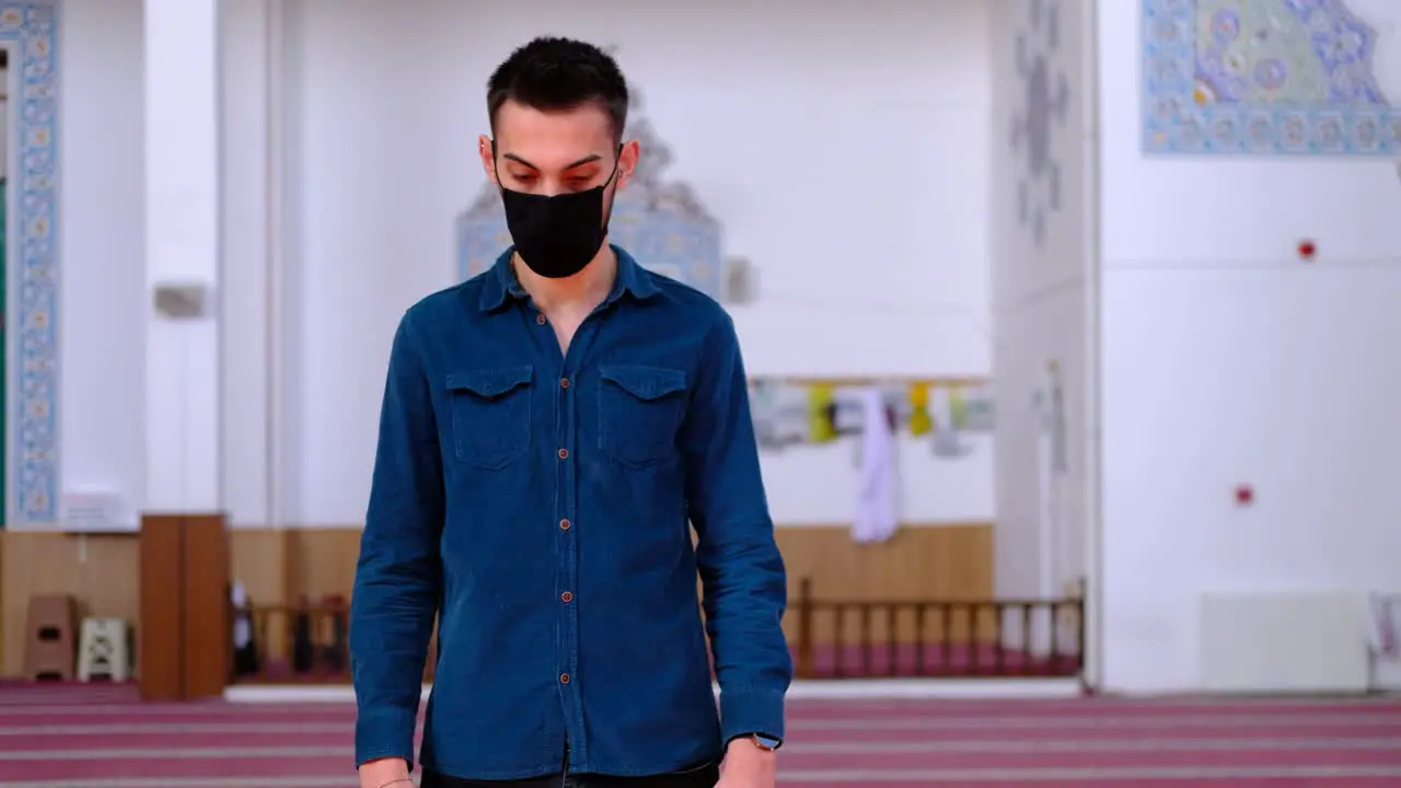 Muslim Worships in A Mask Raises Hands in Prayer in Mosque