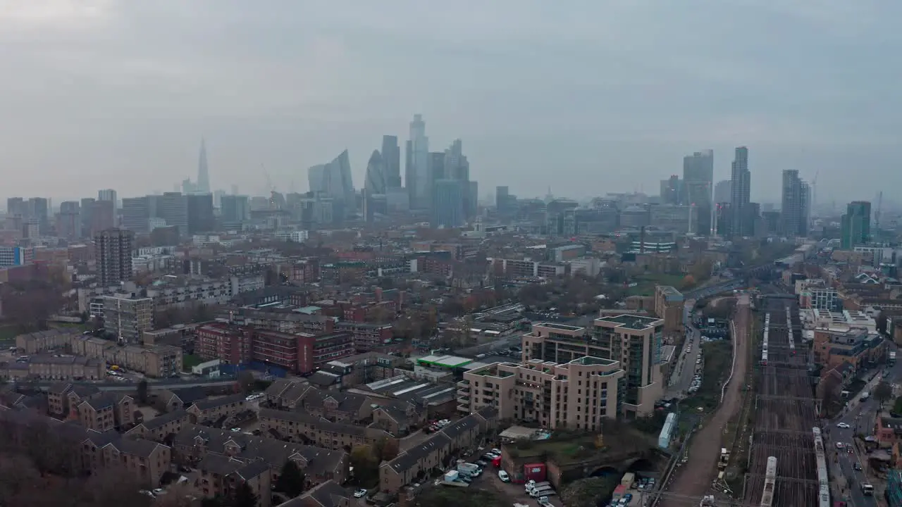 dolly back drone shot of Central London Skyline over overground railway lines