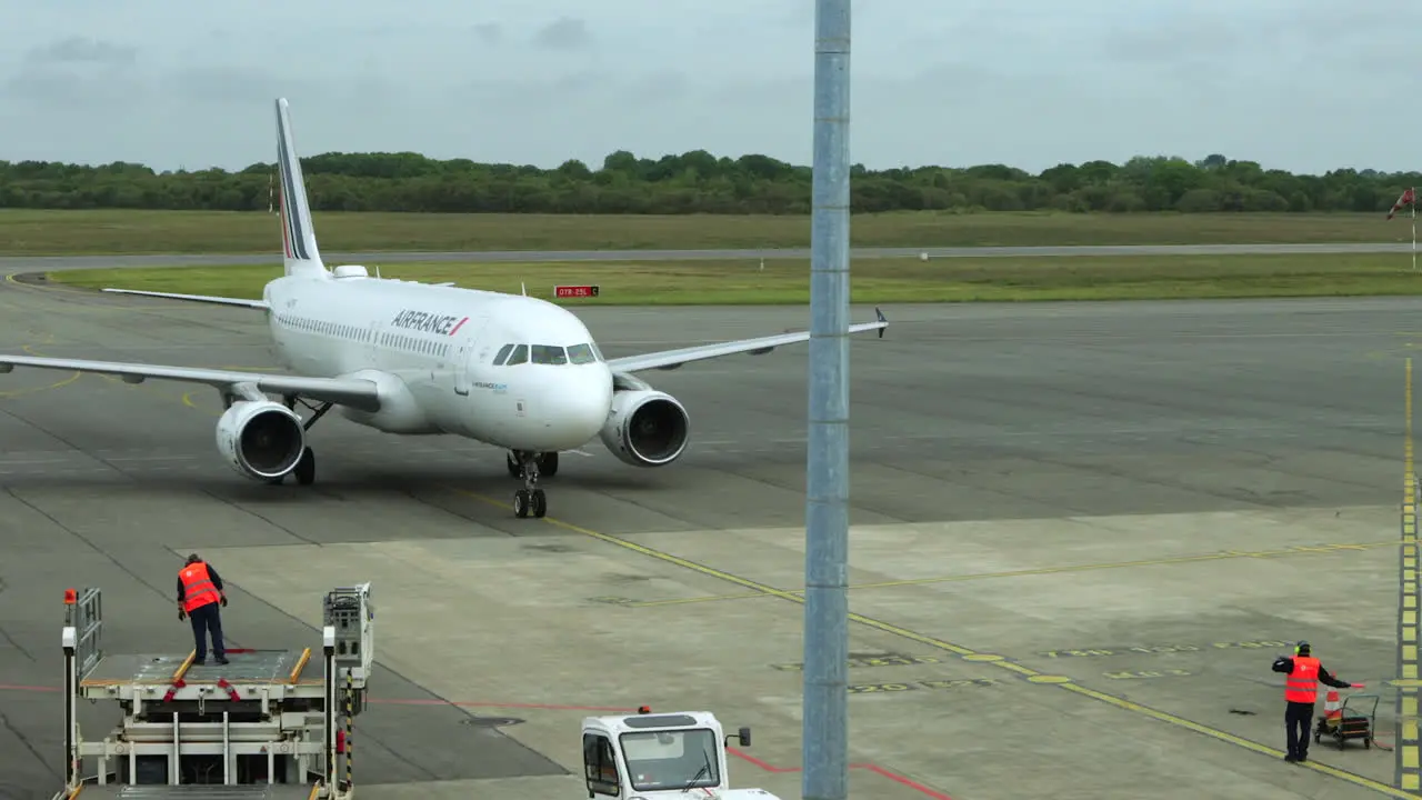 Ground crew guides Air France jet to parking gate at Brest Airport France