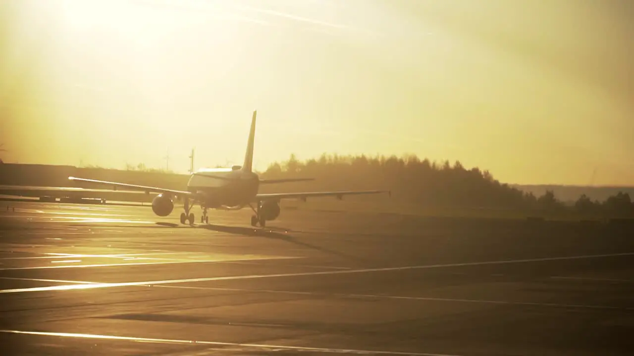 Silhouette of airplane on airport runway during morning sunrise light