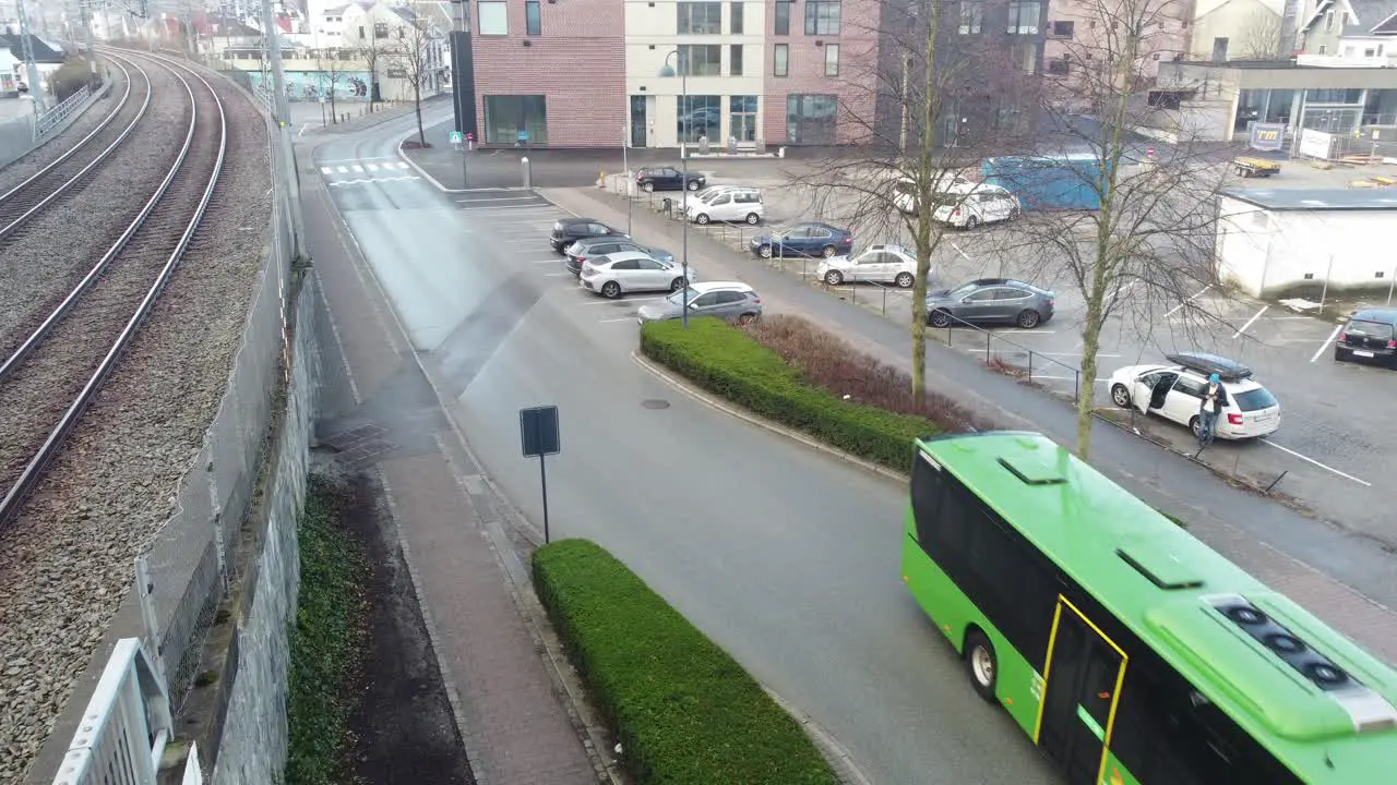 Green colored kolumbus bus is driving through street approaching bus terminal in Sandnes southern Norway