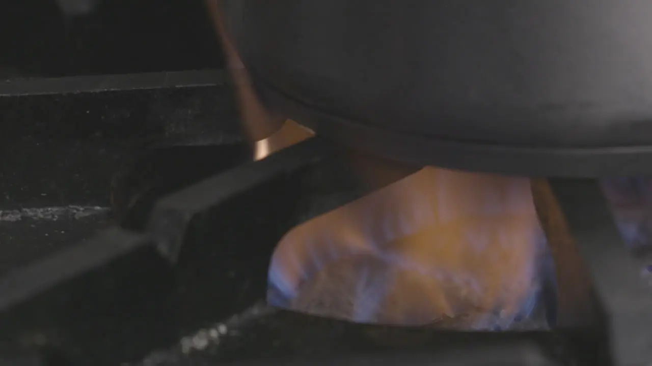 Slow Motion of a burner on an industrial stove top heating a pot