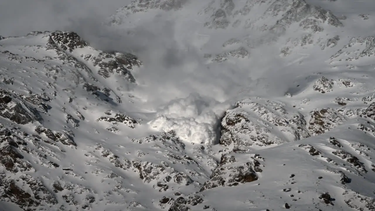 Avalanche fog descends a snowy rocky mountain in the Swiss alps Zermatt