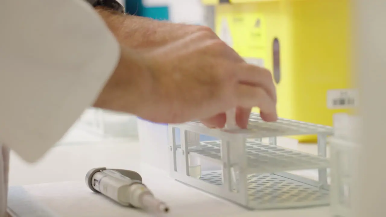 Close Up Of Medical Research Scientist Placing Blood Tubes Into Test Tube Rack On Laboratory Bench 4K