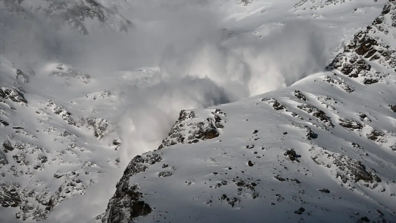 A large foggy avalanche is going down ski slopes Swiss alps Mountains science