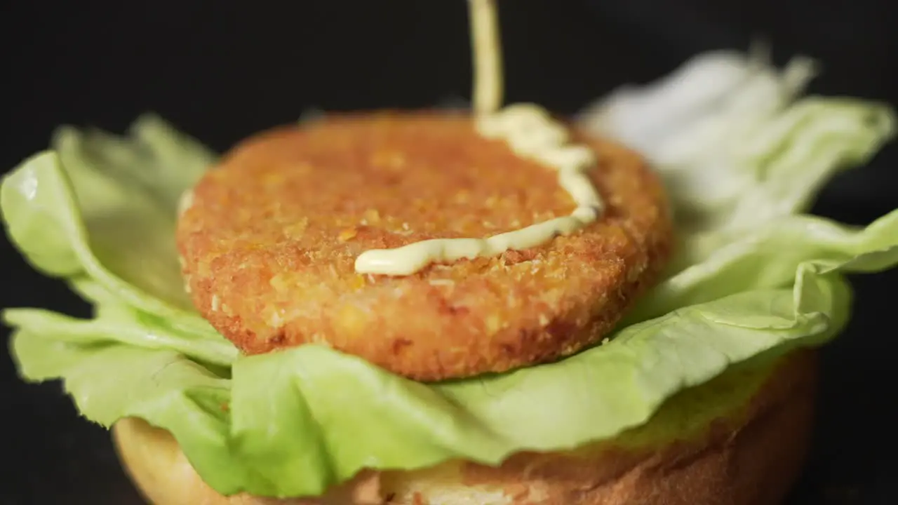 Pouring sauce on burger honey mustard sauce falling on a chicken burger slow motion macro shot