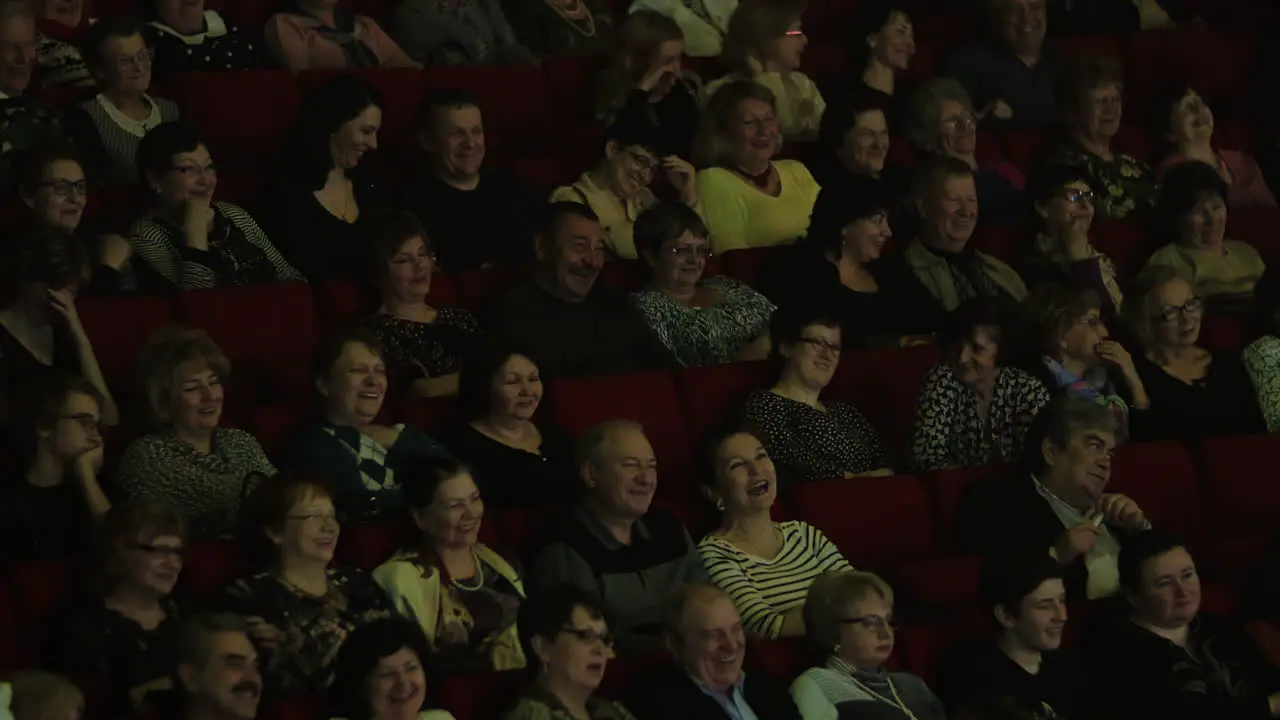 Laughing applauding people in movie hall