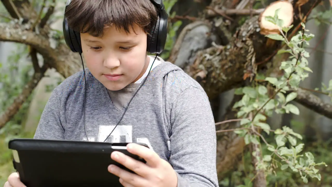 Boy in headphones with touchpad outdoor