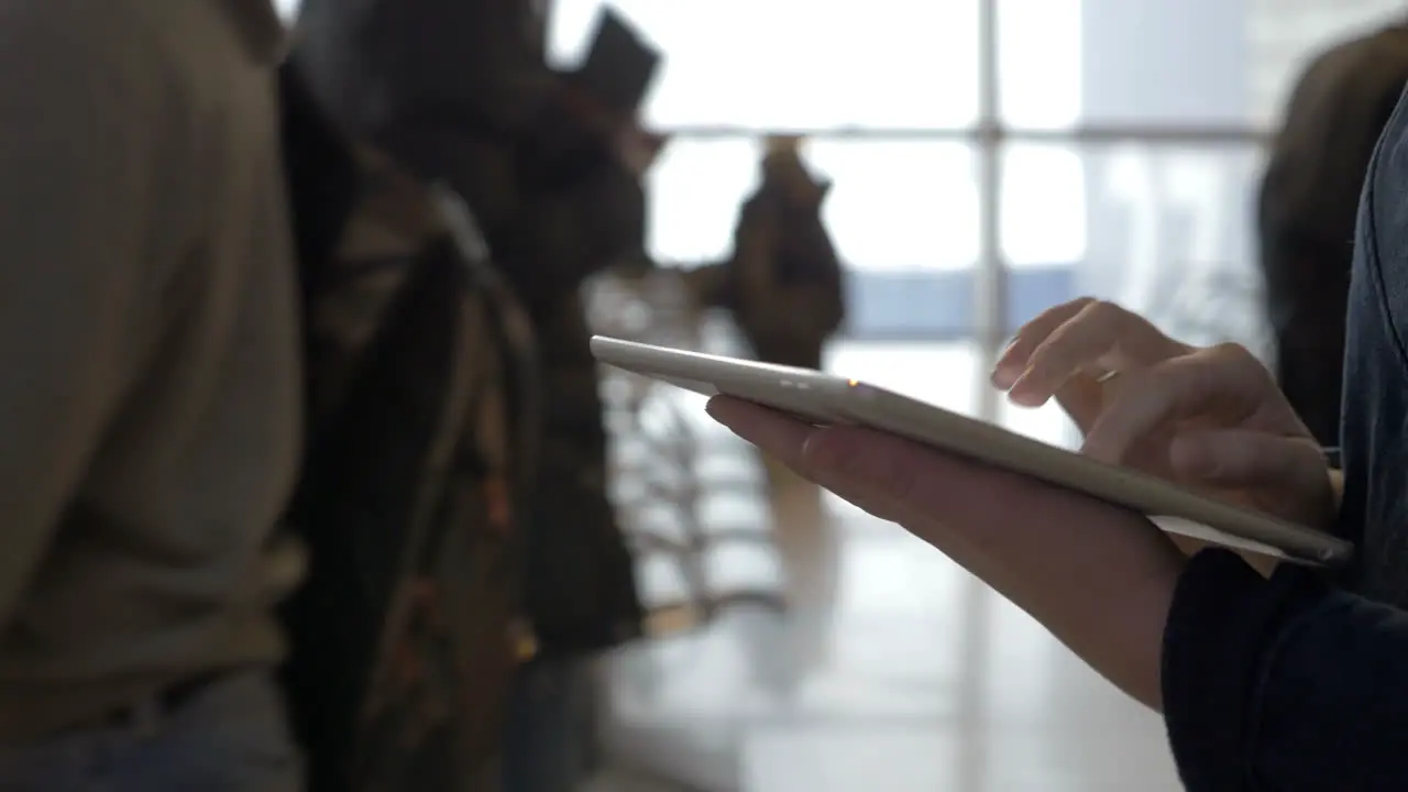 Walking with tablet computer in airport lounge