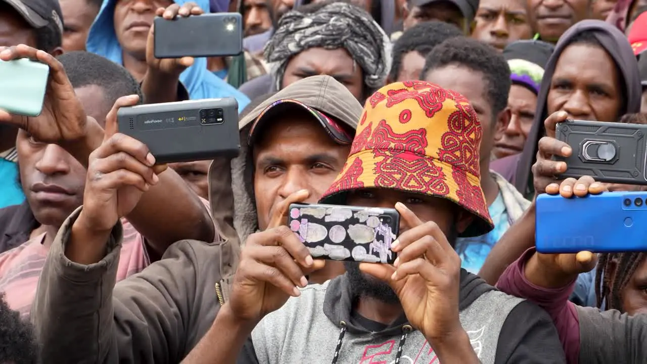 People in crowd take photos with cell phones Papua New Guinea