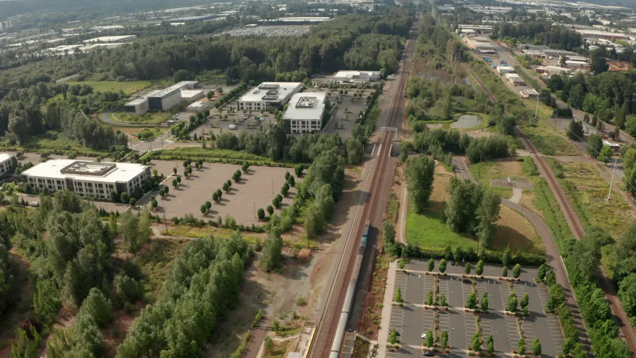 Pan up aerial shot of Amtrak train passing through a station