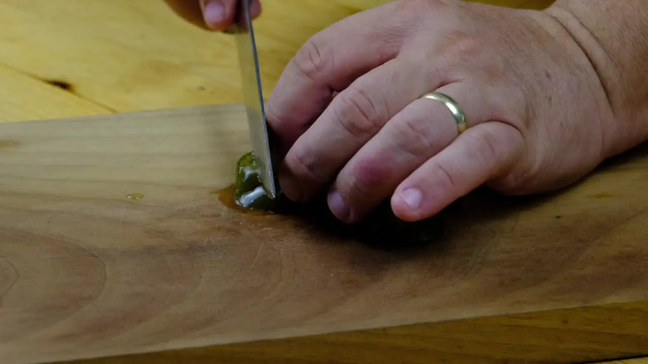 the chef is cutting green pickled hot peppers on a cutting board