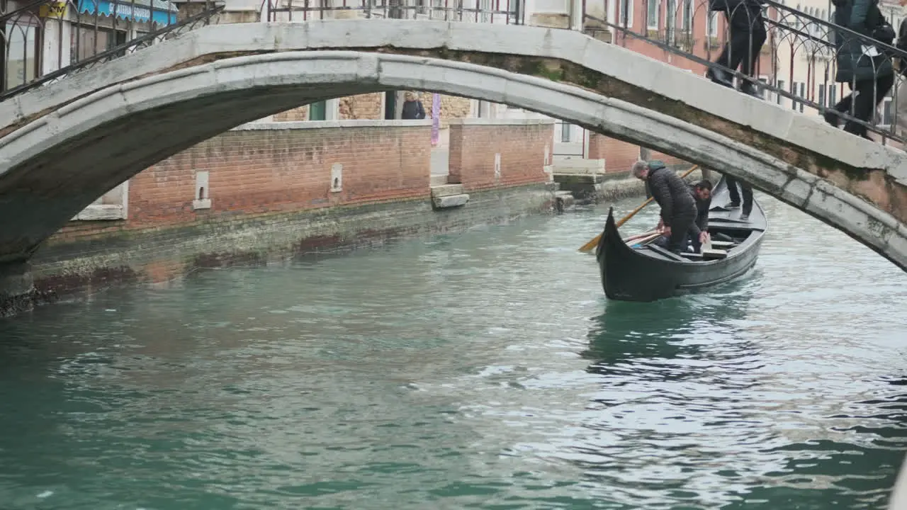 Venetian Gondola under repair passing under a bridge