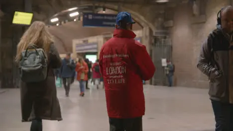 Busy Entrance To London Bridge Rail Station London UK With Man Distributing Free Newspapers