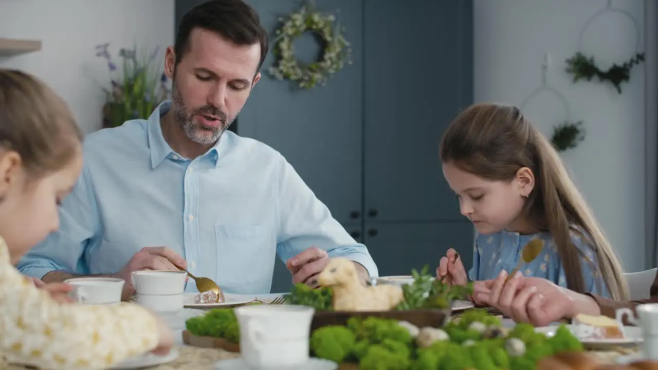 Caucasian family of four eating easter cake at the table