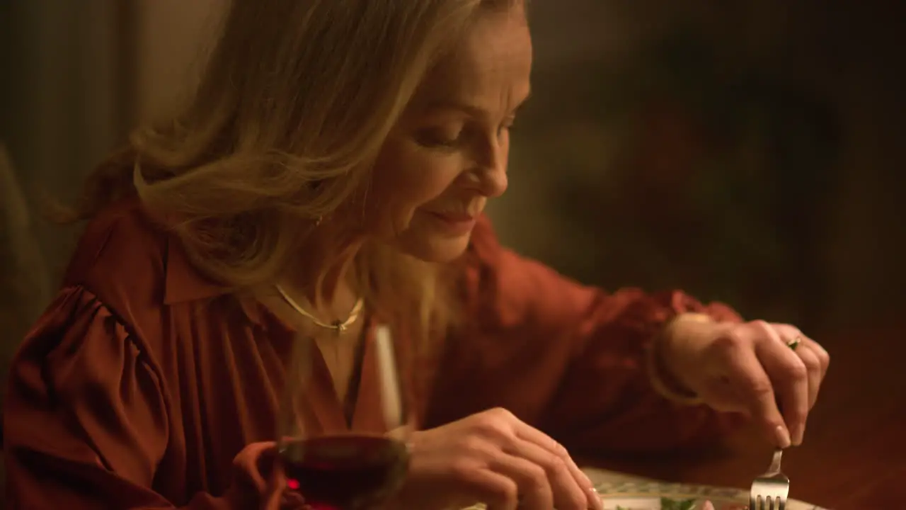 Attractive senior woman eating salad in dusk luxury restaurant Romantic dinner