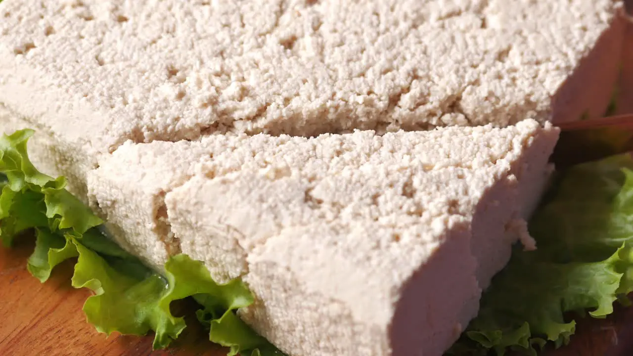 Top view of hands cutting tofu with knife 