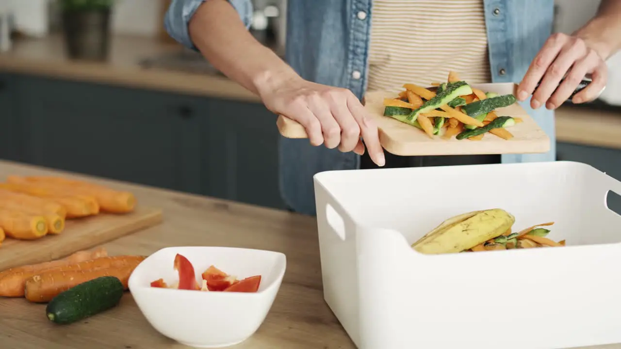 Static video of woman throwing organic waste in the kitchen