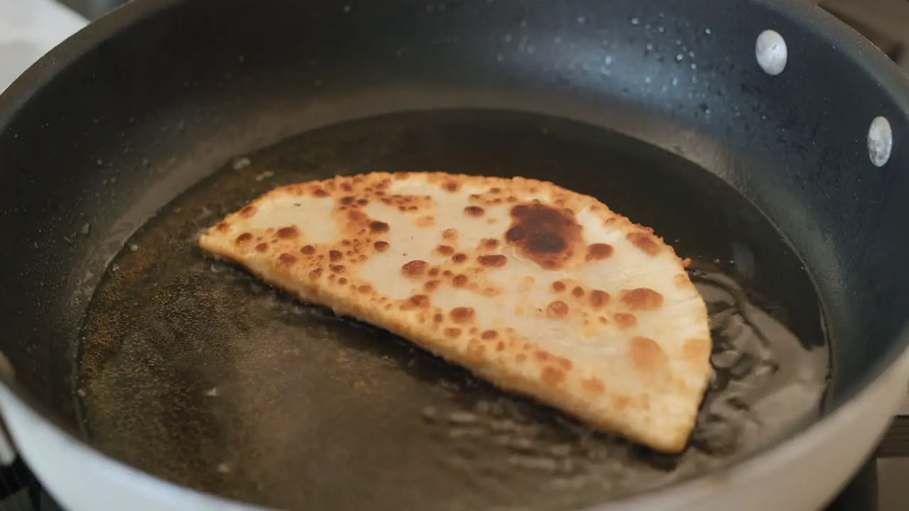 Cheburek is fried in oil in a frying pan