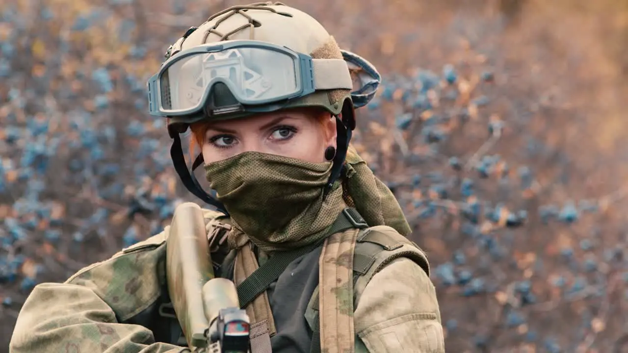 A woman in camouflage aims with a rifle 2