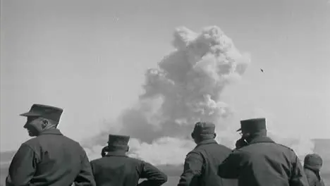 1950s American Military Personnel Observing a Nuclear Bomb Test From a Distance