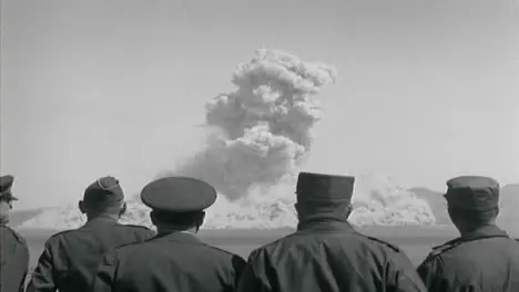 1950s American Military Personnel Observing Nuclear Bomb Test From Distance