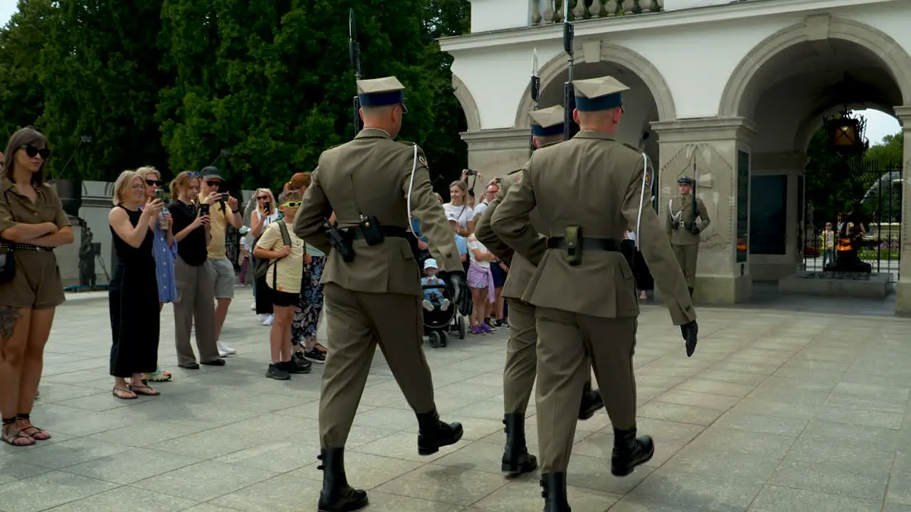 Soldiers with rifles viewed from behind onlookers with cameras Tomb of the Unknown Soldier in Warsaw Poland