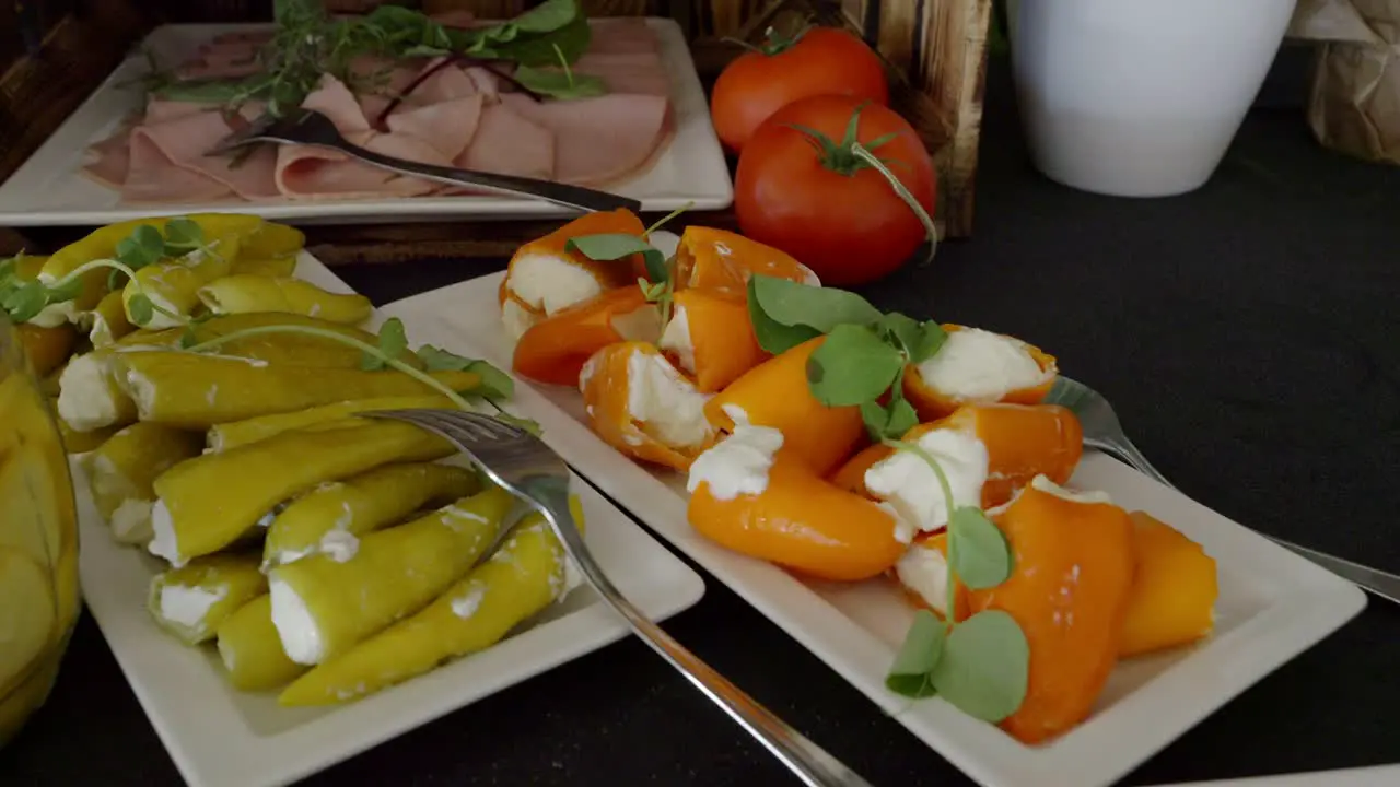 A table with snacks on which there are plates of stuffed bell peppers