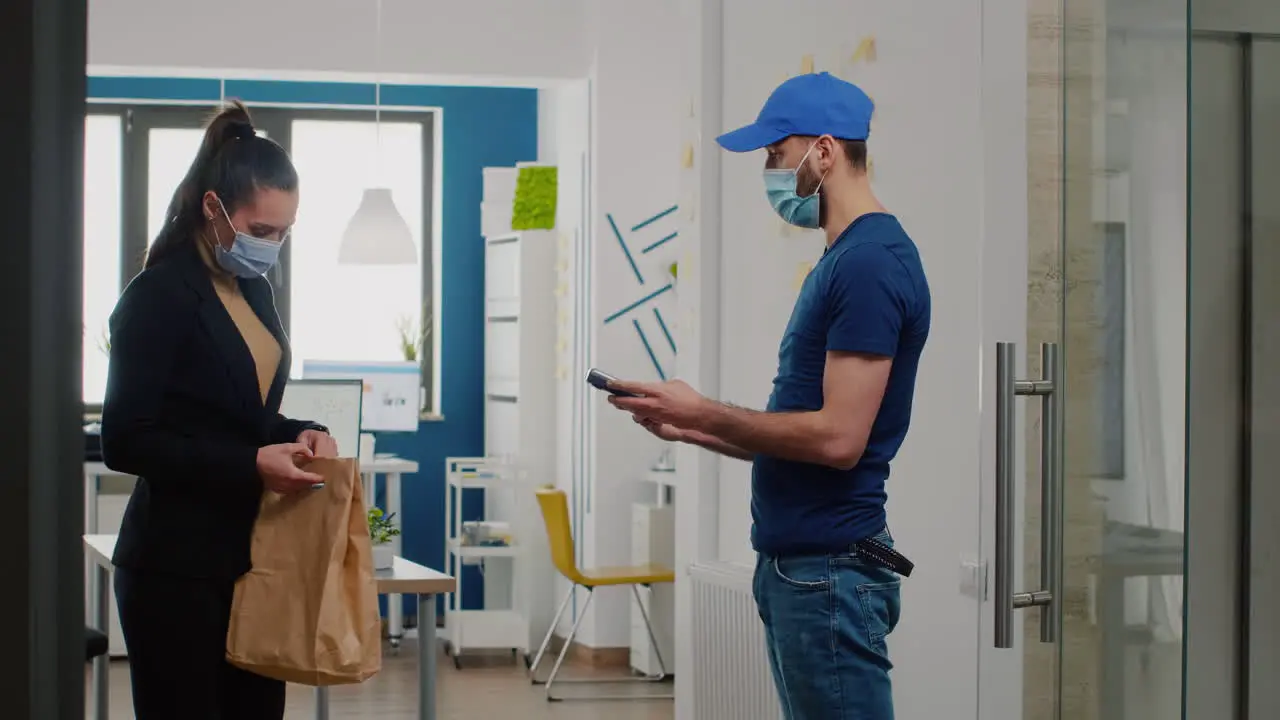 Delivery guy with protection medical face mask and gloves against coronavirus bringing takeaway food lunch