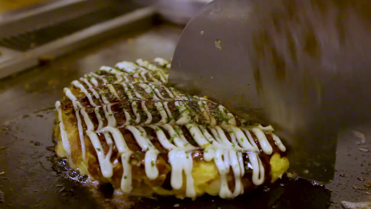 Japanese Food Okonomiyaki Cooked and Cut in Half by expert