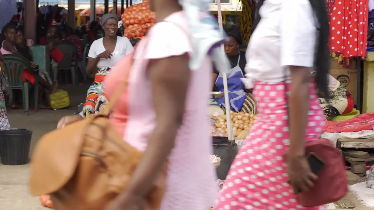 Group of unidentified African women wait for customers to sell their fresh produce at a local street market