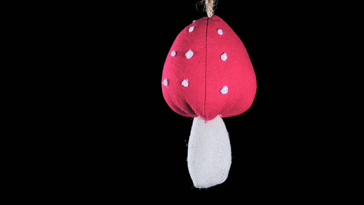 single crochet mushroom Christmas ornament with black background close up