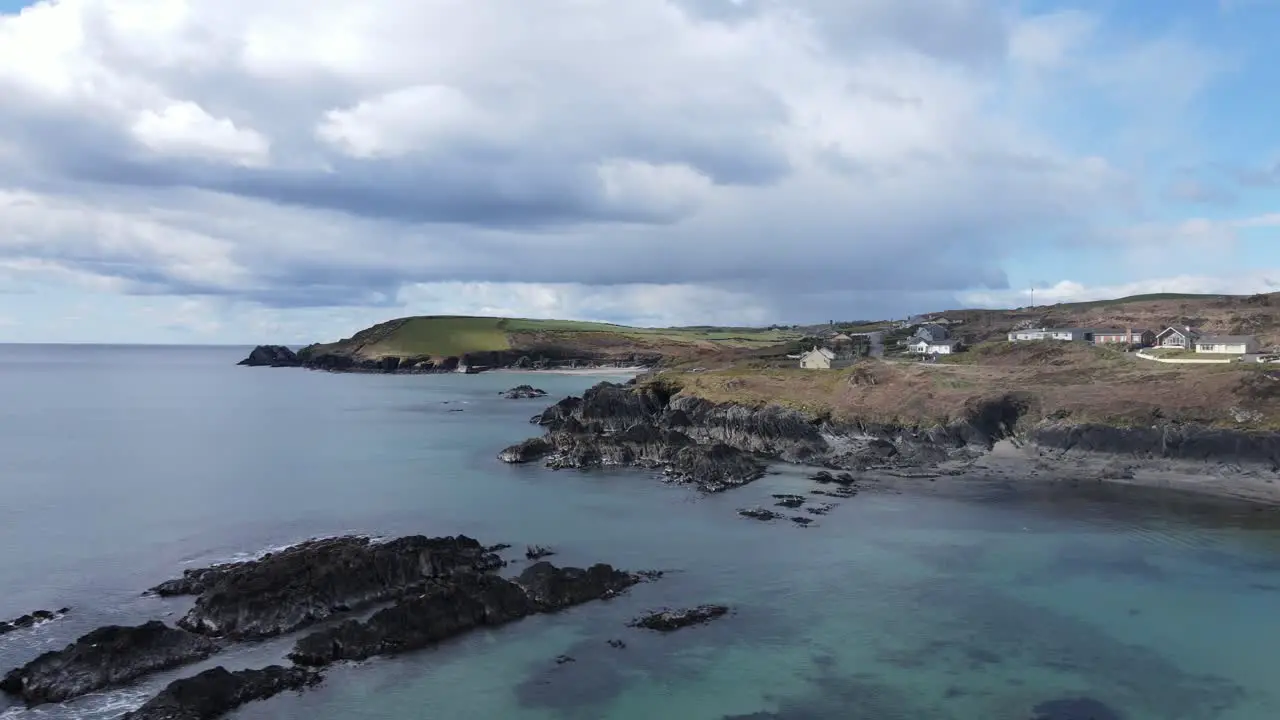 Coastal area from above slide footage over beautiful calm ocean with the view on rugged coast with holiday homes sandy beaches