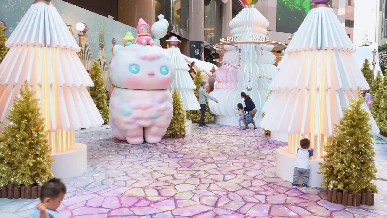 People enjoy an evening at a Christmas theme installation event with golden Christmas trees and different ornaments and decorations in Hong Kong