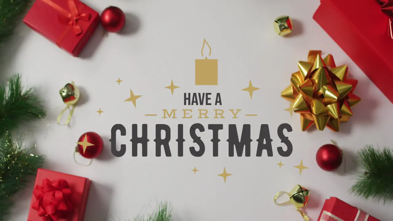 Animation of have a merry christmas text over christmas decorations and gift boxes on table