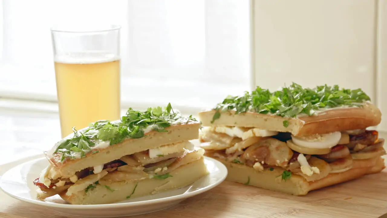 A beautiful shot of sandwich and a beer in a kitchen