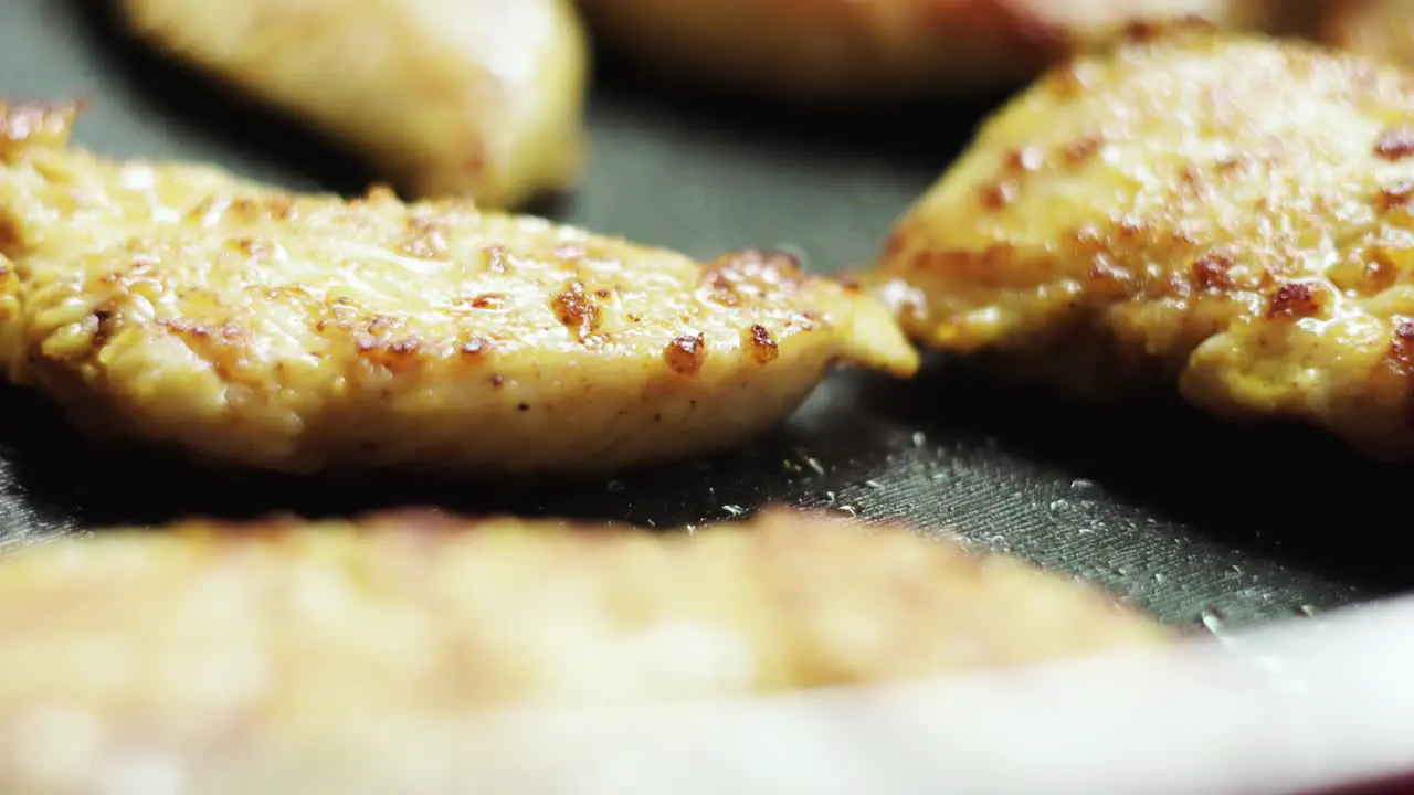 Tasty fried chicken fillet on pan close up